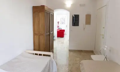 a bedroom with a bed and a room with a door at Between Termini & Colosseo in Rome