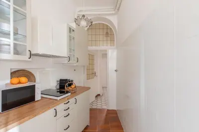 a kitchen with white cabinets and oranges on the counter at iFlat Barberini 's Dream in Rome