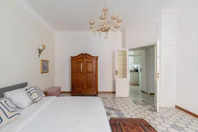 a bedroom with a large white bed and a chandelier at iFlat Barberini 's Dream in Rome