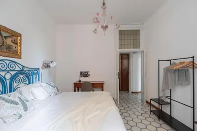 a bedroom with a bed and a desk and a chandelier at iFlat Barberini 's Dream in Rome