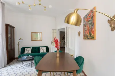 a living room with a table and a green couch at iFlat Barberini 's Dream in Rome