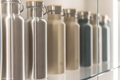 a row of glass bottles sitting on a shelf at Trevi Steps in Rome