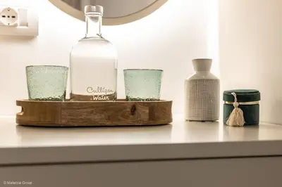 a bottle and glasses sitting on a shelf at Trevi Steps in Rome