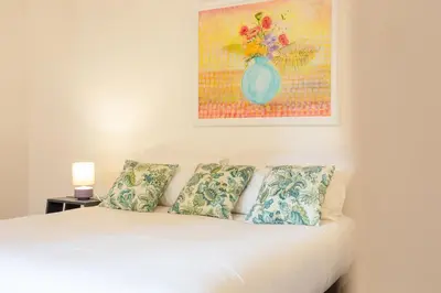 a bedroom with a white bed with pillows and a painting at Casa Cristina in Piazza Farnese in Rome