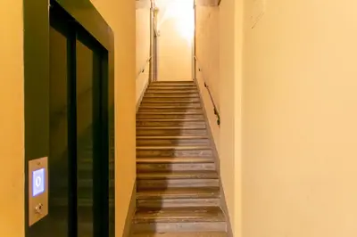 a hallway with stairs in a building with a green door at Casa Cristina in Piazza Farnese in Rome