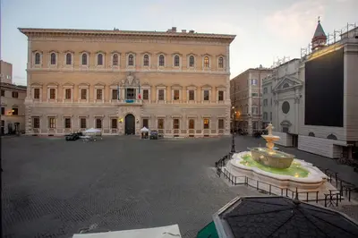 a large building with a fountain in the middle of a street at Casa Cristina in Piazza Farnese in Rome