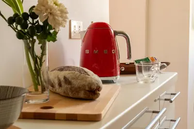 a loaf of bread on a cutting board next to a red appliance at Casa Cristina in Piazza Farnese in Rome