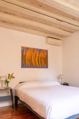 a bedroom with a bed and a painting on the wall at Casa Cristina in Piazza Farnese in Rome