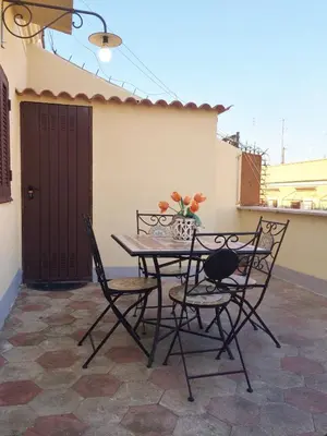 a table and chairs sitting on a patio at Casa Tua sul Tetto di Roma in Rome