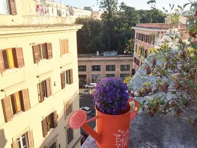 an orange cup filled with purple flowers on a balcony at Casa Tua sul Tetto di Roma in Rome