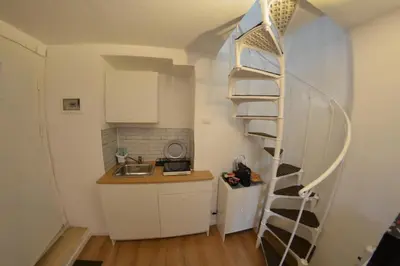 a kitchen with a spiral staircase in a small room at Petit loft de Rome Vatican Apartment in Rome