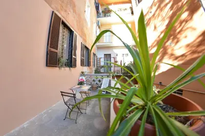 a balcony with tables and chairs and a plant at Petit loft de Rome Vatican Apartment in Rome