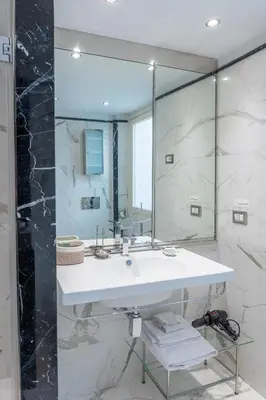 a bathroom with a sink and a large mirror at Suites Rome in Rome