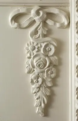 a white object with flowers on a wall at Suites Rome in Rome