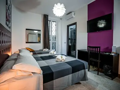 a bedroom with two beds and a desk and a table at Casa Celestina Roma in Rome