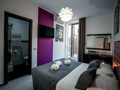 a bedroom with a large bed with a purple wall at Casa Celestina Roma in Rome