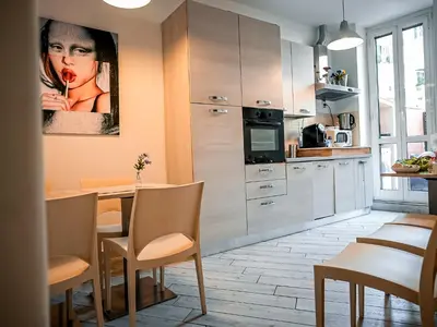 a kitchen with a table and a painting of a woman at Casa Celestina Roma in Rome