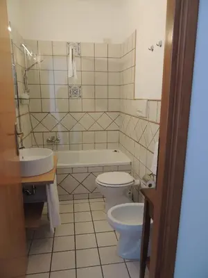 a bathroom with a toilet and a tub and a sink at Madonna della Neve in Rome