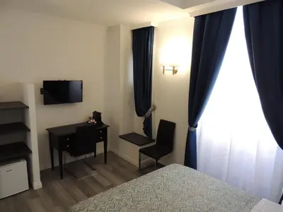 a hotel room with a bed and a desk and a television at Madonna della Neve in Rome