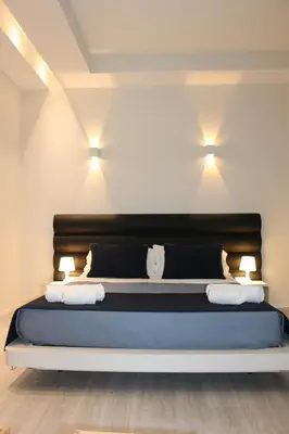 a bedroom with a bed with two lights on the wall at Little Rose Lodge in Rome