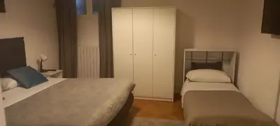 a small bedroom with two beds and a cabinet at La maison de Rome Vatican Apart in Rome