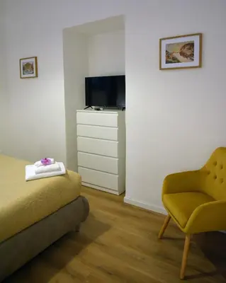 a bedroom with a couch and a chair and a television at La maison de Rome Vatican Apart in Rome