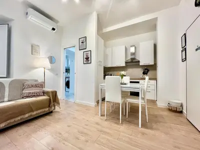 a living room and kitchen with a table and chairs at Saint Peter 78 - Design Apartment in Rome