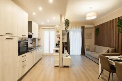 a kitchen and living room with a couch and a table at Albadomus Apartment in Rome