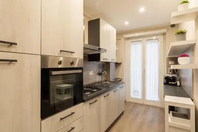 a kitchen with wooden cabinets and a stove top oven at Albadomus Apartment in Rome