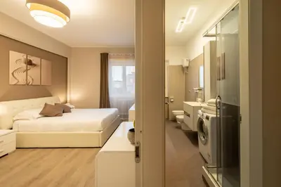a hotel room with a bed and a bathroom at Albadomus Apartment in Rome