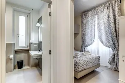 a small bedroom with a bed and a sink and a window at INN3 APT in Rome