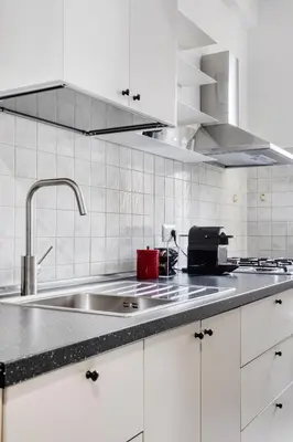 a kitchen with white cabinets and a sink at Yellow Stripes Apartment - San Giovanni by RHR in Rome