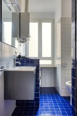 a bathroom with a sink and a blue tile floor at Yellow Stripes Apartment - San Giovanni by RHR in Rome