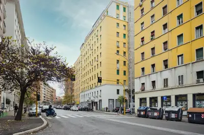a yellow building on the side of a city street at Yellow Stripes Apartment - San Giovanni by RHR in Rome