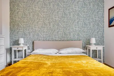 a bedroom with a bed with a gold bedspread at Yellow Stripes Apartment - San Giovanni by RHR in Rome