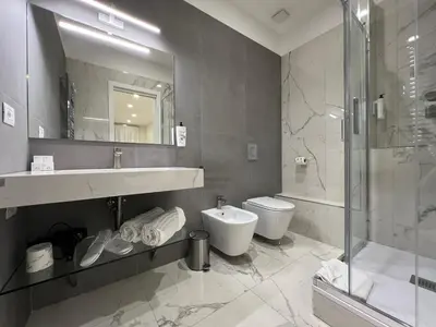 a bathroom with a sink and a toilet and a shower at Vittoria's Luxury Rooms in Rome