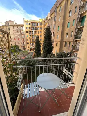 a table and chairs on a balcony with buildings at Vittoria's Luxury Rooms in Rome