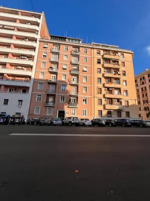 a large apartment building with cars parked in front of it at Vittoria's Luxury Rooms in Rome