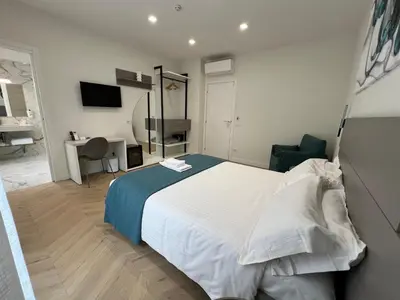 a bedroom with a large white bed and a desk at Vittoria's Luxury Rooms in Rome