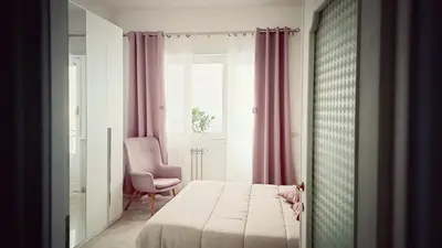 a bedroom with a bed and a chair and a window at ROMA BeMa Apartment - charme e relax a due passi dal Vaticano in Rome