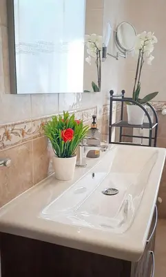 a bathroom with a white sink with flowers on it at ROMA BeMa Apartment - charme e relax a due passi dal Vaticano in Rome