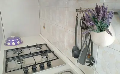 a kitchen stove with a vase of purple flowers at ROMA BeMa Apartment - charme e relax a due passi dal Vaticano in Rome