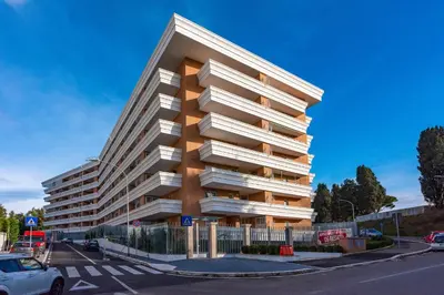 a tall building with white balconies on a street at Marcus Modern Apartment in Rome
