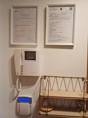 a room with a phone on a wall with two pictures at Marcus Modern Apartment in Rome