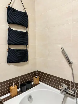 a bathroom with a tub and a towel rack with towels at Marcus Modern Apartment in Rome