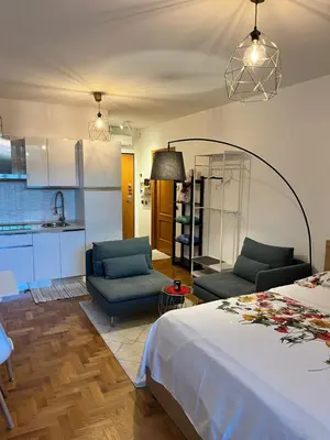 a bedroom with a bed and two chairs and a kitchen at Marcus Modern Apartment in Rome