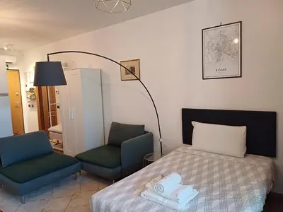 a bedroom with a bed and two chairs at Marcus Modern Apartment in Rome