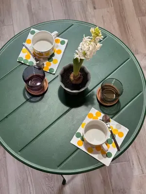 a green table with plates and a vase with flowers on it at Navona 68 in Rome