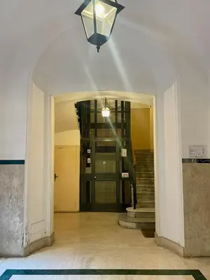 a hallway with an archway with a staircase and a light at Professor's house in Porta Pia in Rome