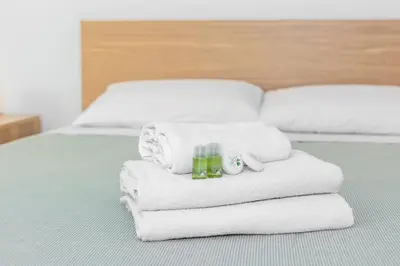 a pile of towels and candles on a bed at Professor's house in Porta Pia in Rome